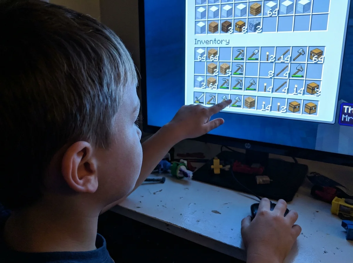 Close-up of child carefully organizing Minecraft inventory demonstrating resource management and prioritization decisions